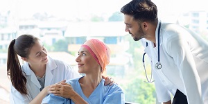 Paciente con cáncer junto a dos médicos