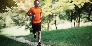 Hombre corriendo por un parque durante el fin de semana