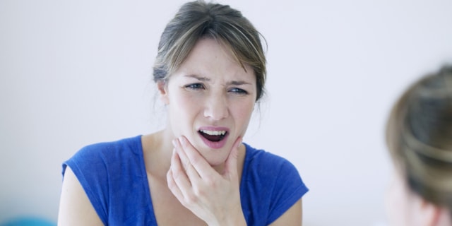 Mujer con dolor en mandíbula