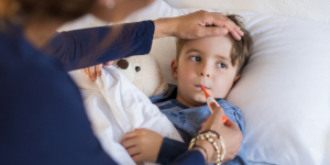 niño enfermo con termómetro