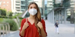 mujer con mascarilla en la ciudad